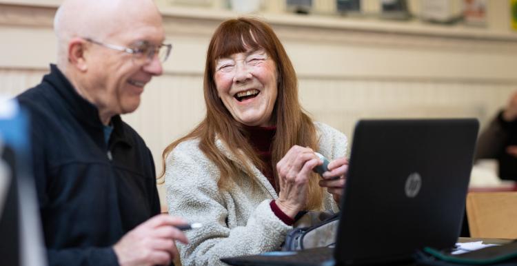 Older man and woman using laptop