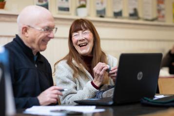 Older man and woman using laptop