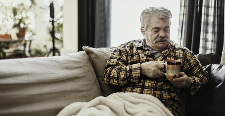 Man with blanket and hot drink