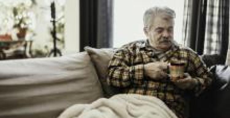Man with a hot drink keeping warm at home