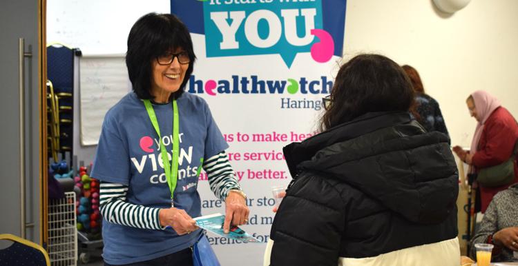 Healthwatch volunteer engaging woman on Healthwatch stall