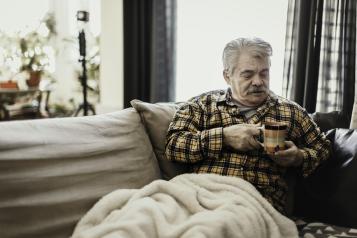 Man with blanket and hot drink