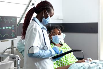 Black Woman hospital bed with doctor