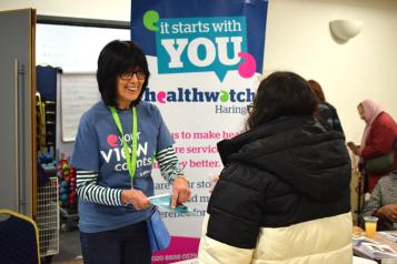 Healthwatch volunteer engaging woman on Healthwatch stall
