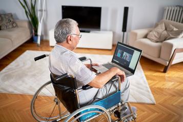 Older white man in a wheelchair having an online chat
