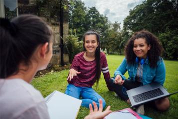 Teen girls sitting having a discussion outdoors