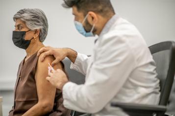 Older Asian woman receiving a vaccine