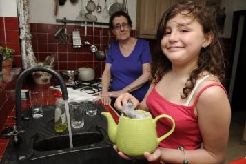 A young female carer helping her mum in the kitchen