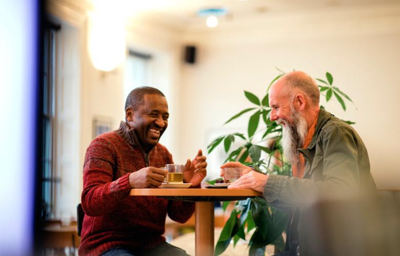 Two men sitting at a table laughing with each other