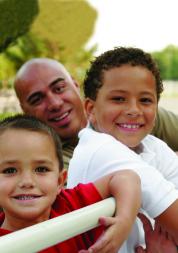 Man smiling with his two young children
