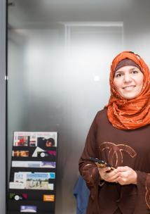 woman wearing a headscarf holding her mobile phone